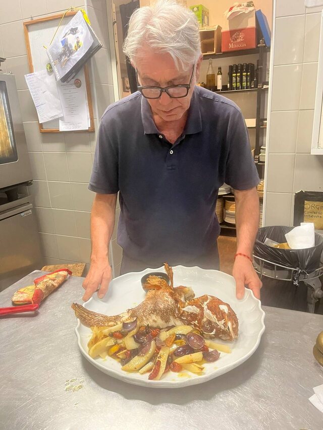 Vassoio di pesce arrosto con patate preparato nella cucina de La Rocchetta