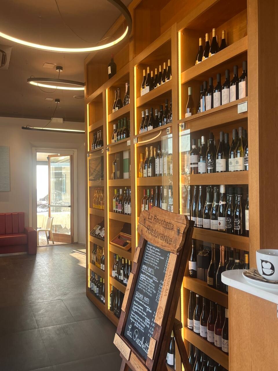La parete dei vini de La Rocchetta illuminata con luce calda